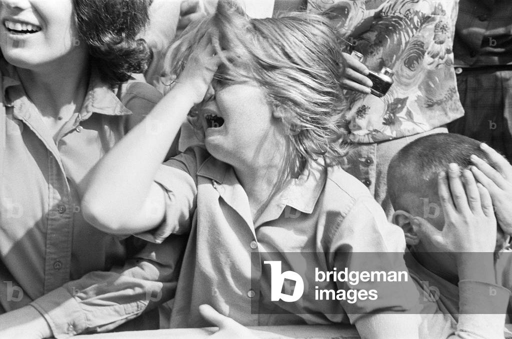 The Beatles in New York City, on their North American Tour ahead of their concert to be held at Forest Hills. Cheering fans gathered outside the Delmonico Hotel in New York where the band are staying. 28th August 1964 (b/w photo)