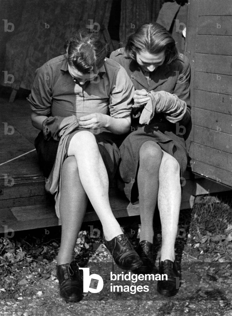 Mending their stocking at training and reception Depot for ATS girls in Aldermaston, Berkshire, April 1941 (b/w photo)