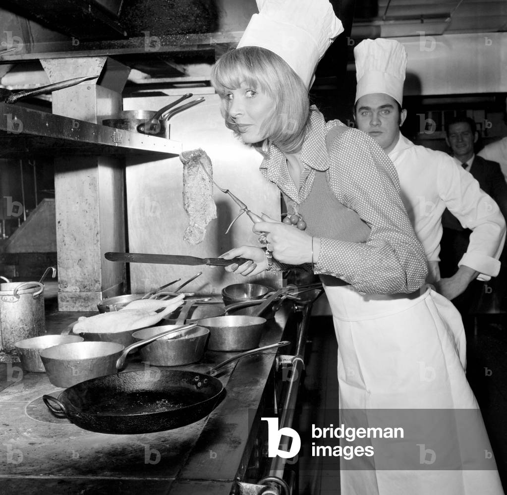 Miss World, 1972: Belinda Green: 20 year old Belinda Green, a blonde haired, blue eyed, model from Australia, won the Miss World Contest. Belinda's favourite hobby is cooking. Belinda in the kitchens of the Britannia Hotel, where she is staying, making herself something to eat this morning, December 1972 (b/w photo)