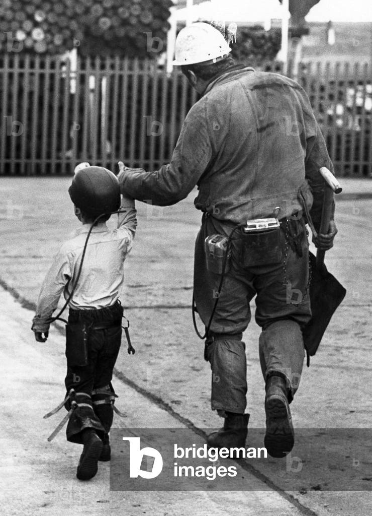 A coal miner walking his son, a junior miner. 
October 1978