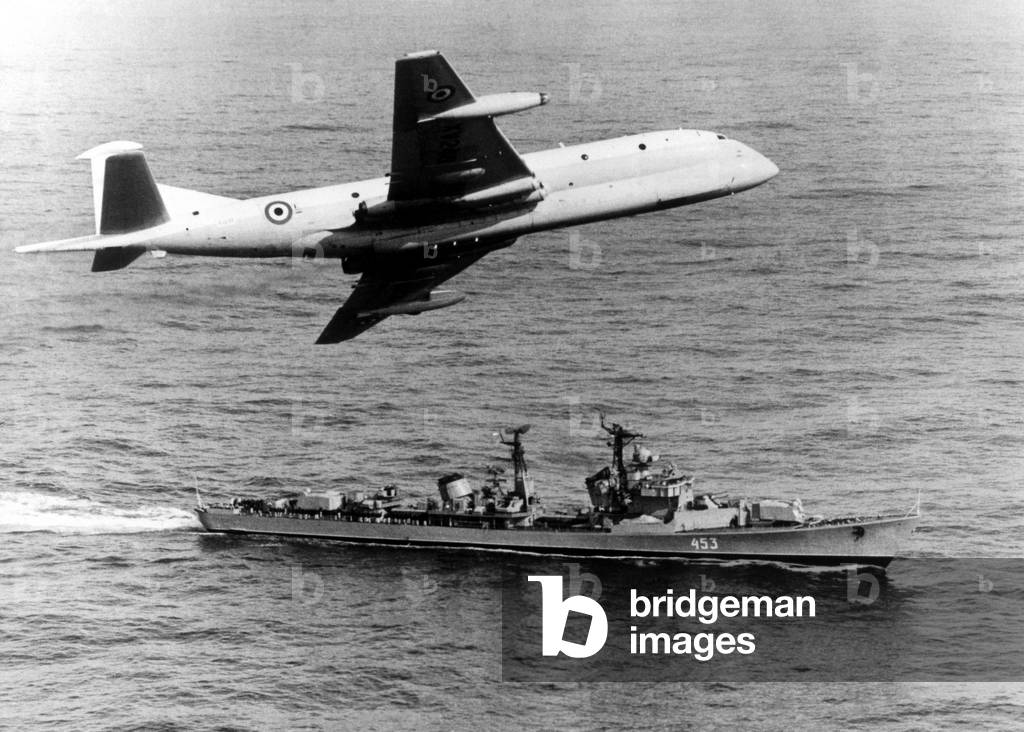 A RAF Hawker Siddeley (Bae) Nimrod maritime patrol aircraft, of 296 squadron, keeps a watchful eye on a Soviet guided missile destroyer as it approaches the oil rig Neptune Seven in the Orkneys area., c. 1976 (b/w photo)