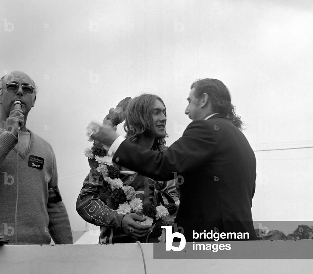 John Player British Grand Paix, Silverstone. Ron Haslam being presented with the winner's cup by Mr. Nicholls of the Daily Express, August 1977 (b/w photo)