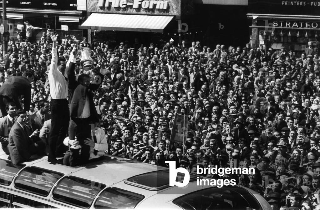 West Ham United celebrate winning the FA Cup at Wembley in 1964 showing off the trophy to their fans in the East End of London (photo)