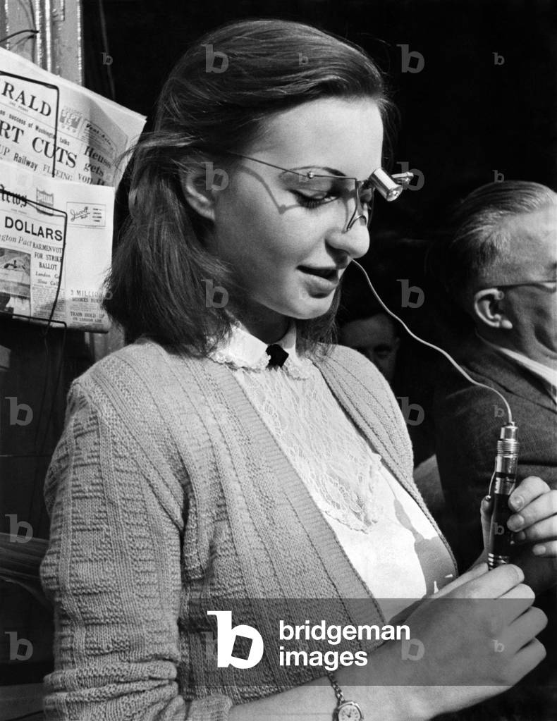 London typist Miss L.B. Fatt using light over typewriter, and examining idea with inventor Paterson, as show in pix. September 1949
