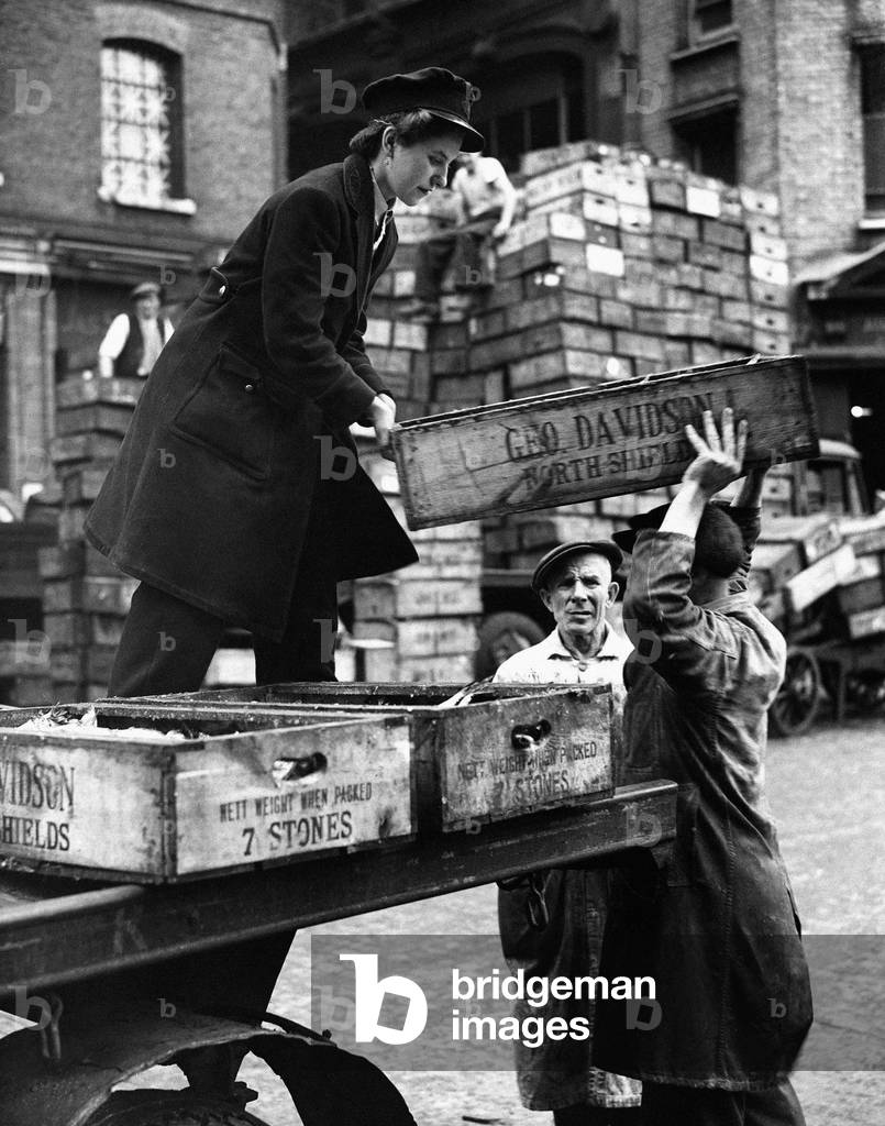 World War Two Home Front. A woman delivery boxes full of fish to traders in Billingsgate market, London September 1943 (b/w photo)