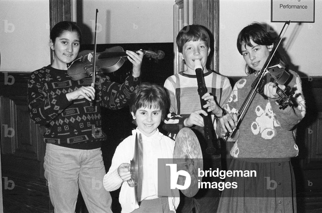 Sarah Tariq (Birkby Junior School), Kirsty Gentry (Cowersley Junior School) and Jonathan Heap (Netherthong Junior School) during the Kirklees Primary School Music festival at Huddersfield Town Hall, 22nd March 1988 (b/w photo)