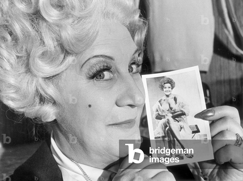 Mrs Slocombe (Actress Molly Sugden) seen here showing off her passport photograph for a Grace Brothers staff trip to Spain in the film of the tv series 