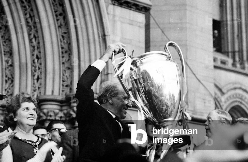 Manchester United Football Team return after winning the European Cup - Matt Busby holds the cup high outside Manchester town hallJune 1968 (photo)