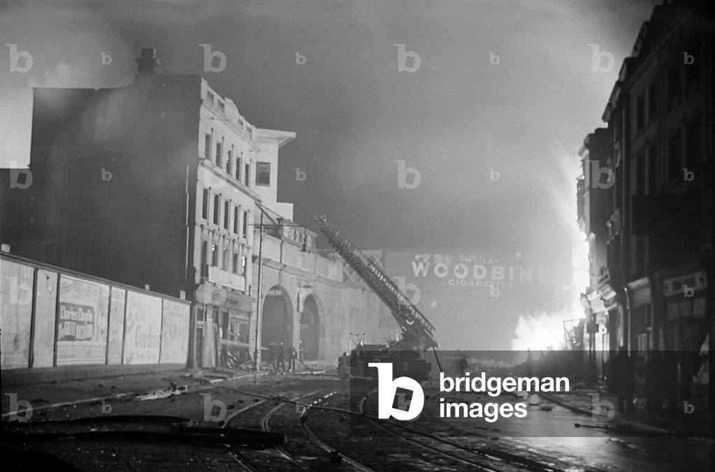 Fireman tackle a blaze in the Waterloo area cause by High Explosive bombs during the 2nd Fire of London, December 1940 (b/w photo)