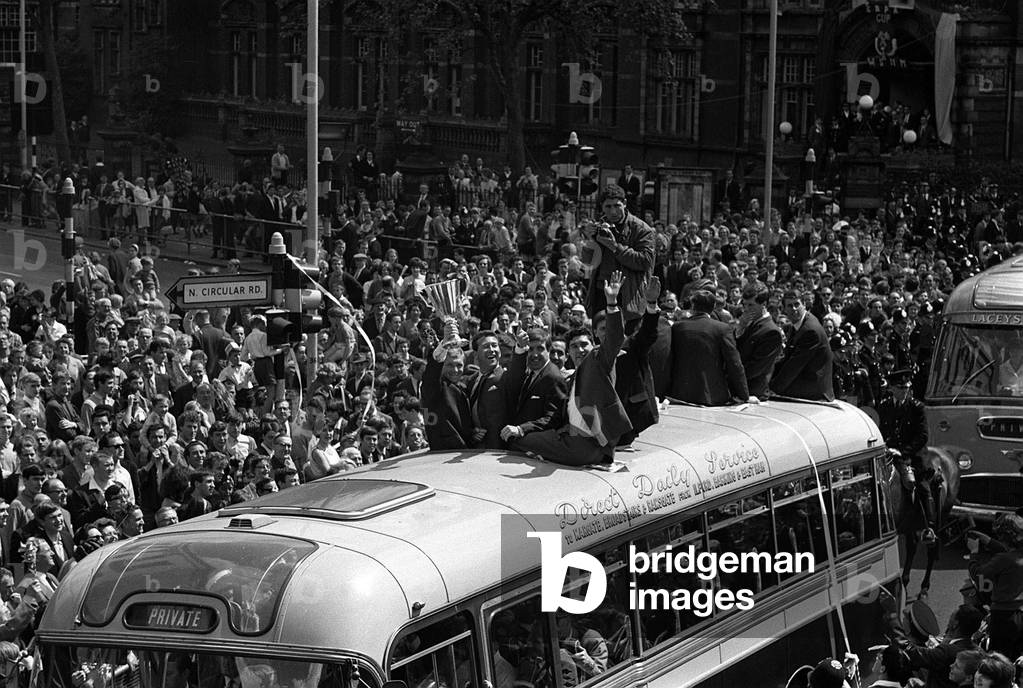 Captain Bobby Moore presents the European Cup Winners Cup trophy to the people of West Ham from the top of the team coach during their victory parade through the streets of East LondonMay 1965 (photo)