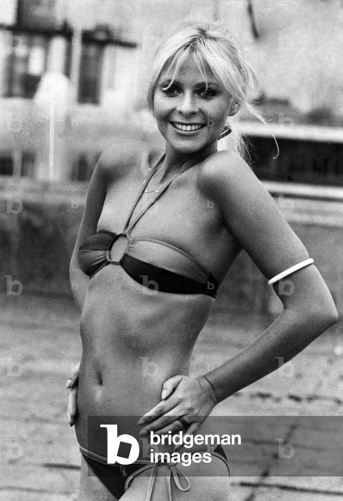 Clothing Beach Swimwear: Triumph International swimwear and Beachwear collection for 1976. A Comprehensive collection of styles to suit all shapes, sizes, tastes and budgets is offered by Triumph International in their new swim and beach wear collection for 1976 - available at the beginning of the year. Nixe wearing a blue and white halter necked bikini. Retail price £3.95 and made in Polymide. August 1975