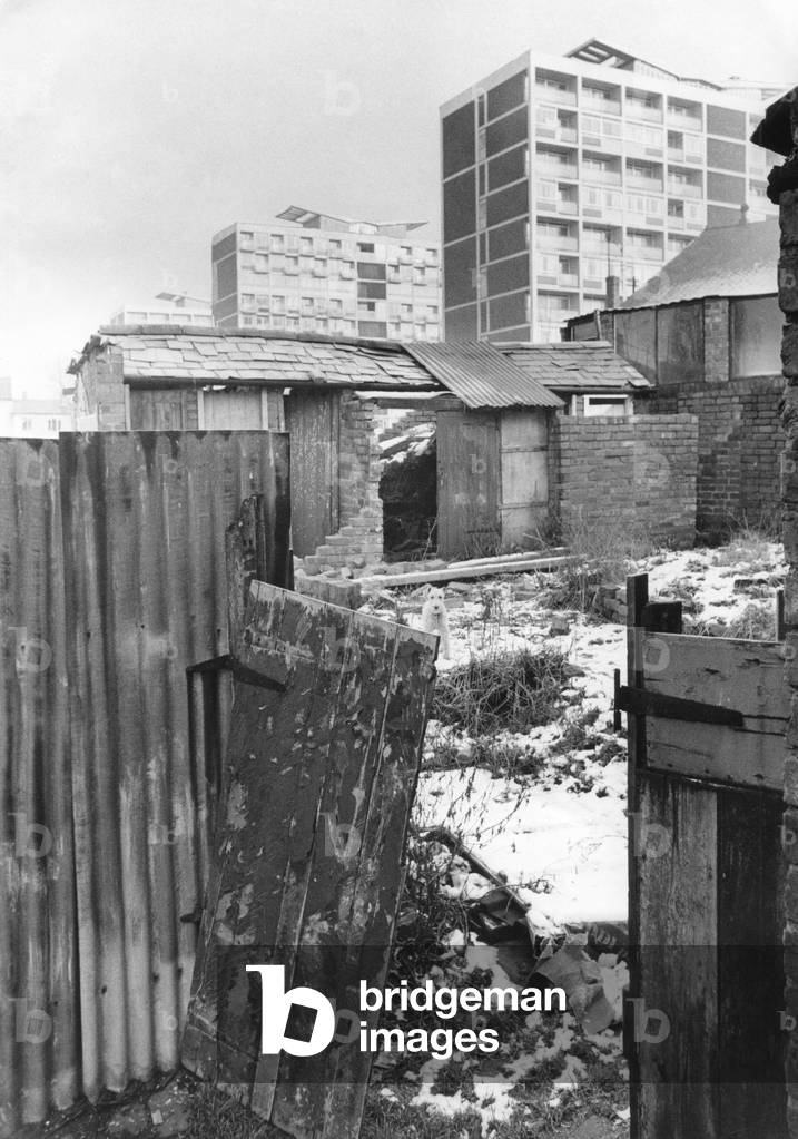 Flat dwellers look down on a huddle of crumbling outhouses in Hillfields, Coventry. 11th February 1970 (b/w photo)