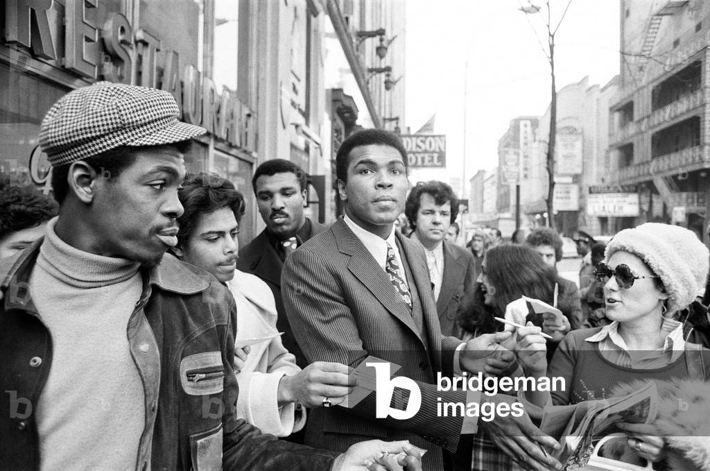 Muhammad Ali signing autographs ahead of his rematch with Joe Frazier. 23rd January 1974 (b/w photo)