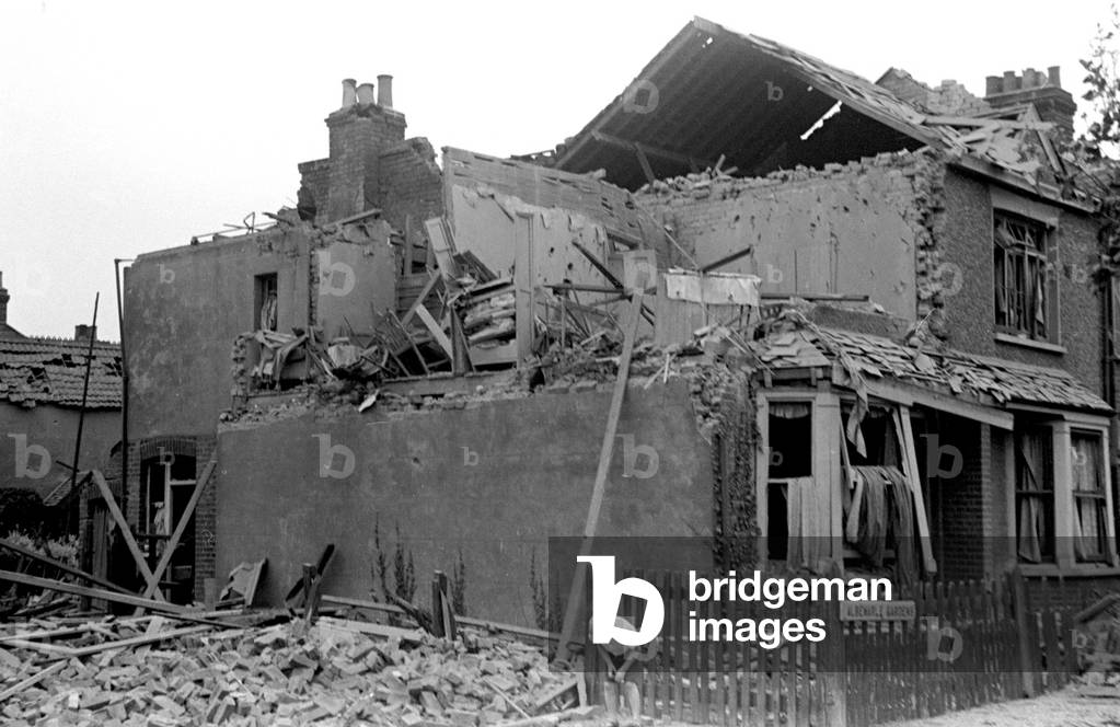 Alfieri. Air raid damage at Malden, London. A young boy sifts through the rubble. 16th August 1940