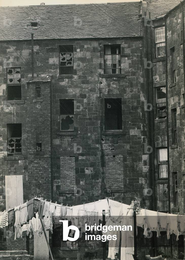 Housing slums in the Dalmarnock district of Glasgow the derelict tenement housing with its windows broken a load of washing is hung out to dry, October 1963 (b/w photo)