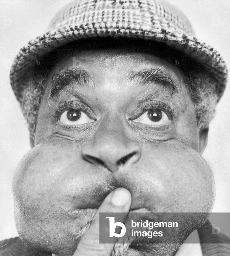 American jazz musician Dizzy Gillespie puffing out his cheeks during a visit to Middlesbrough, where he played at a jazz festival.