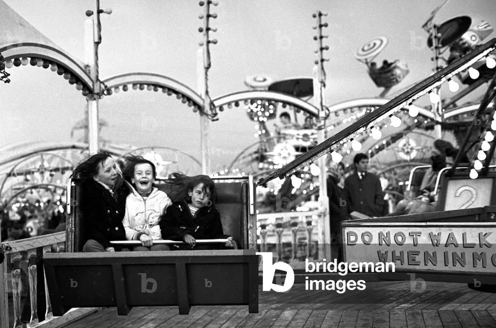 Hearsall Common Easter fair, Coventry. Children take a ride on a roundabout at the fairground.
28th May 1967