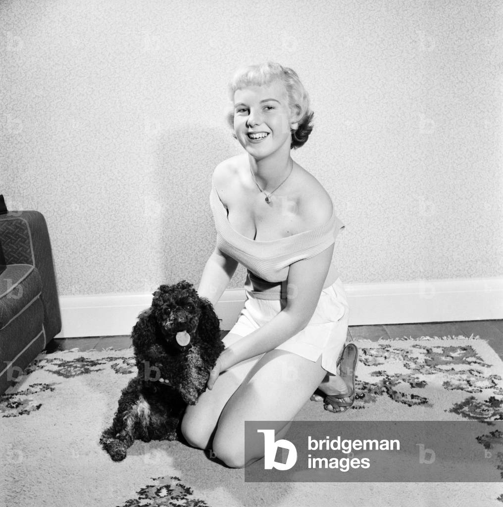 Pat Bolton seen here with her pet poodle dog, 1964 (b/w photo)