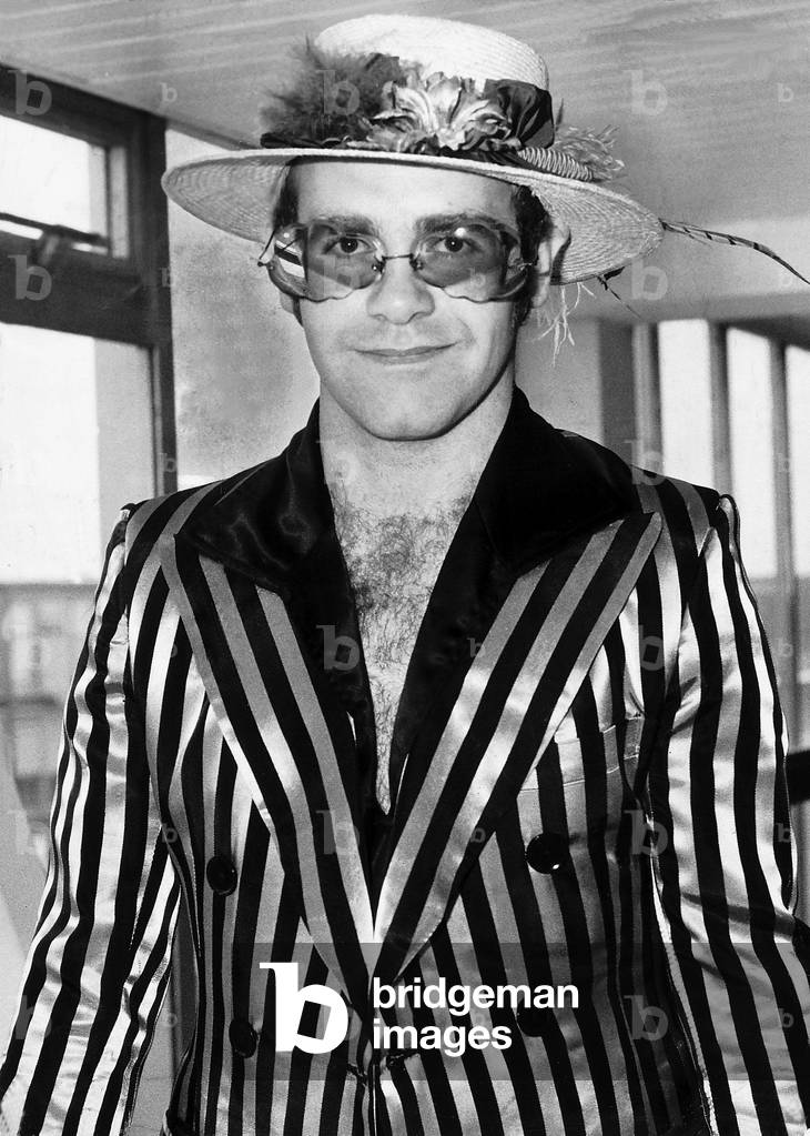 Elton John Pop singer passes through Heathrow Airport on his way back from Los Angeles, 31/08/1974 (b/w photo)