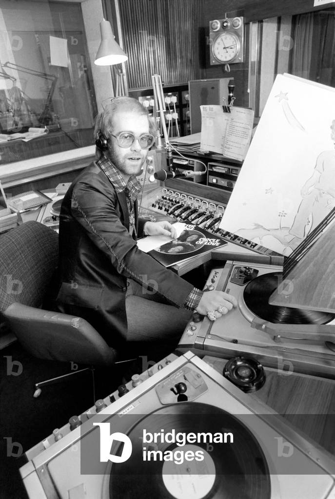 Elton John records his first programme as a disk jockey at the BBC this afternoon (Sunday), March 1976 (b/w photo)