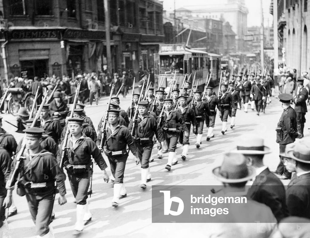 A large force of Japanese sailors marching from their ship through the streets of the foreign settlement of Shanghai, China shortly before the start of the Chinese Civil War. April 1927 (b/w photo)