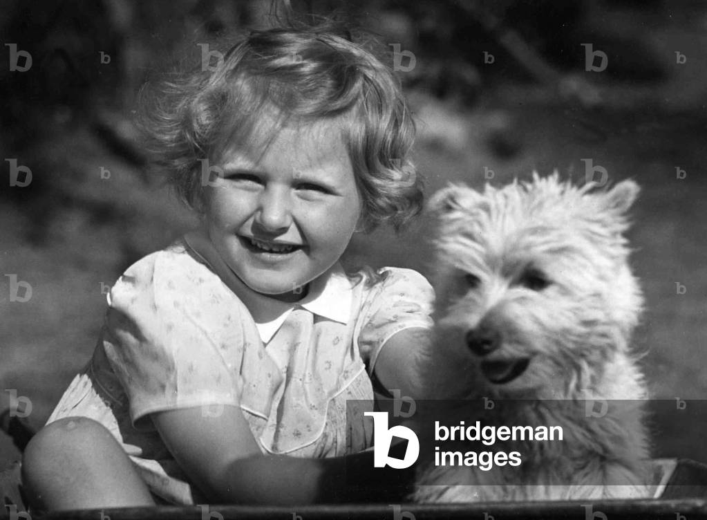 Young girl sitting with dog. c. 1945