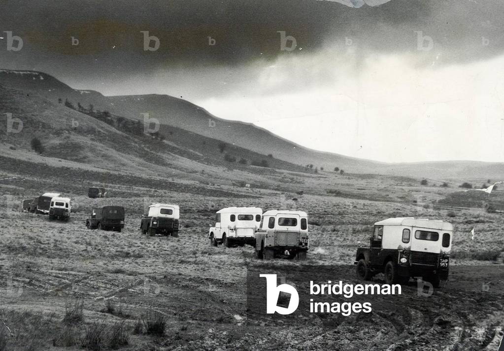 Churning through layers of mud, a line of Land Rovers move cross country towards the Black Mountains in Wales, 14th March 1960 (b/w photo)