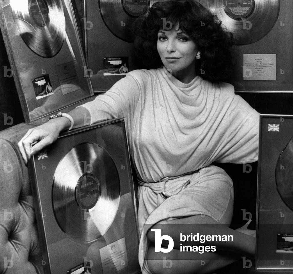 Joan Collins actress presented with a Golden Record to celebrate sales in the UK in excess of 100,000 units for the soundtrack recording on Warwick Records of her latest Film The Bitch, March 1980 (b/w photo)
