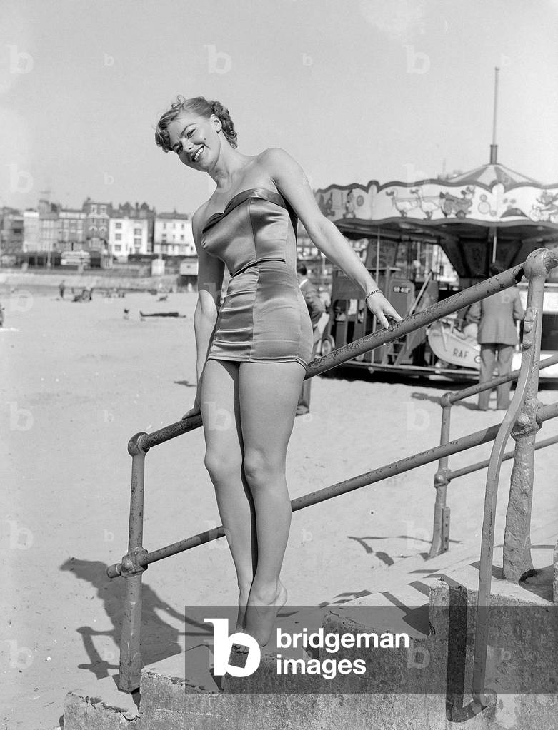 Clothing Beach wear swimsuits fashion April 1952
Model standing on steps wearing a onepiece swimming costume