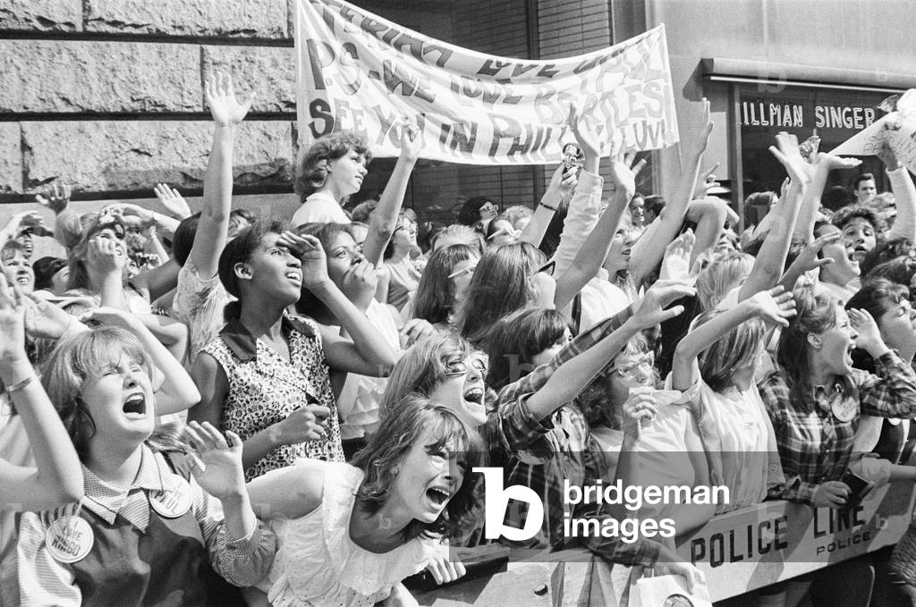 The Beatles in New York City, on their North American Tour ahead of their concert to be held at Forest Hills. Cheering fans gathered outside the Delmonico Hotel in New York where the band are staying. 28th August 1964 (b/w photo)