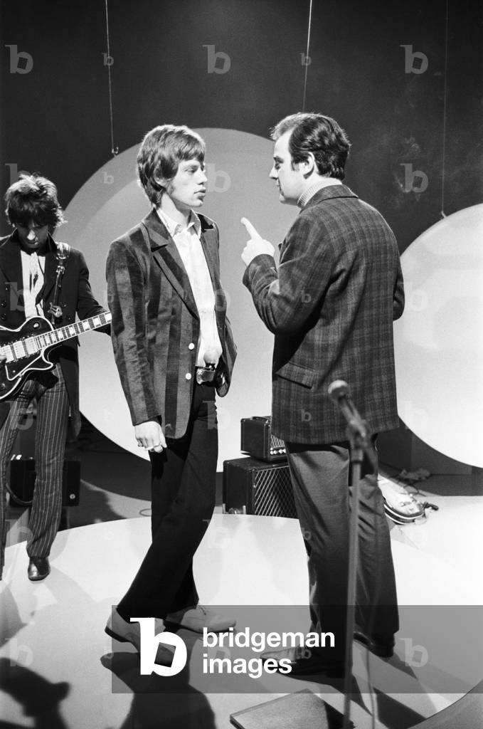 Mick Jagger (Repetto chaussure) talks to the TV director during rehearsals at Teddington for the Eamonn Andrews show on which the Rolling Stones appeared on 5 February 1967 (b/w photo)