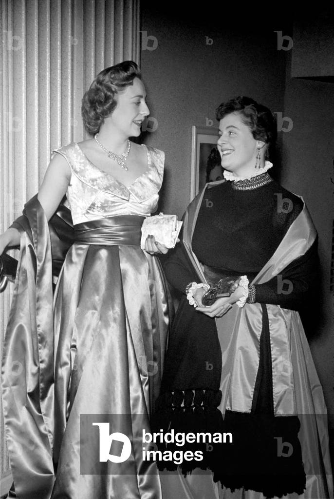 Actress Jane Hylton in an open necked evening dress, designed by Sheila Graham, who is seen with her in a high necked dress with an Klizabethan ruff, also designed by herself. October 1952 C5360-001