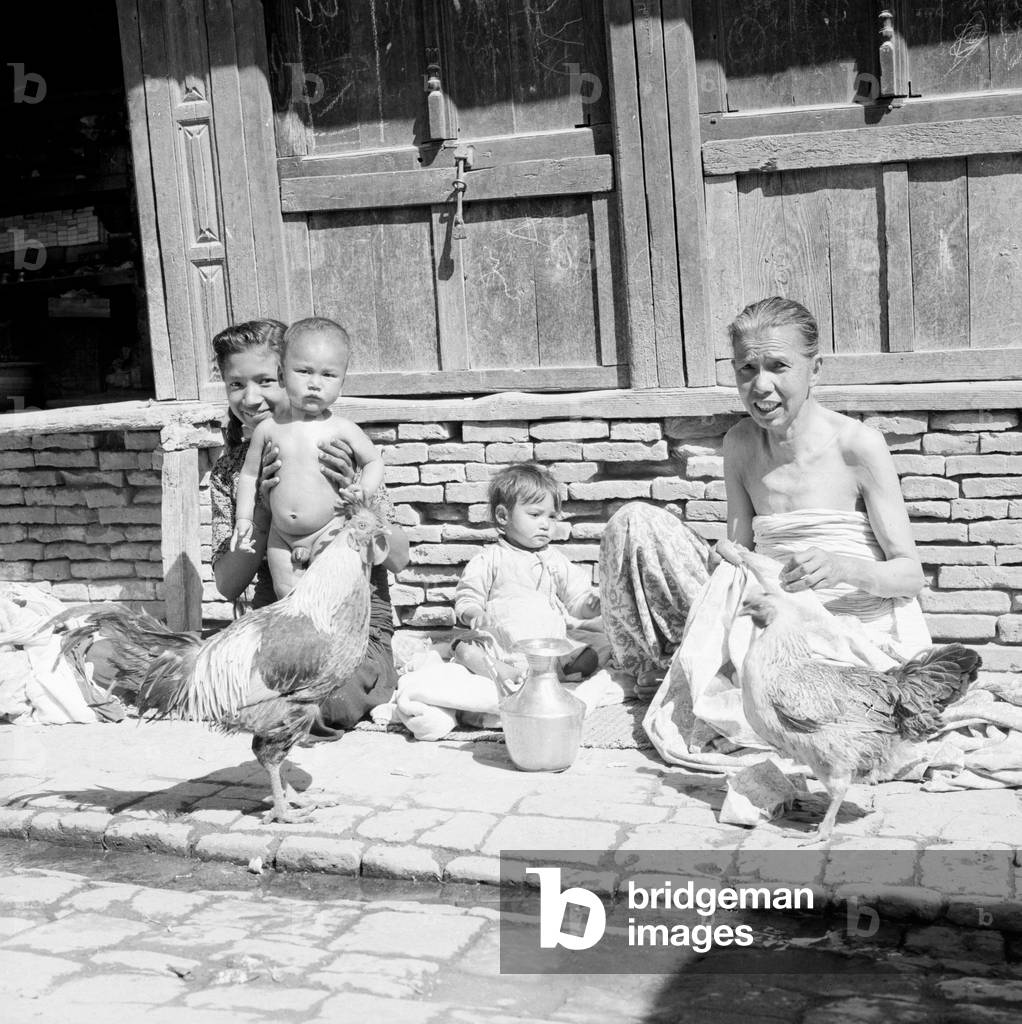 Nepalese family seen here on the streets of Katmandu with their chickens, February 1961 (b/w photo)