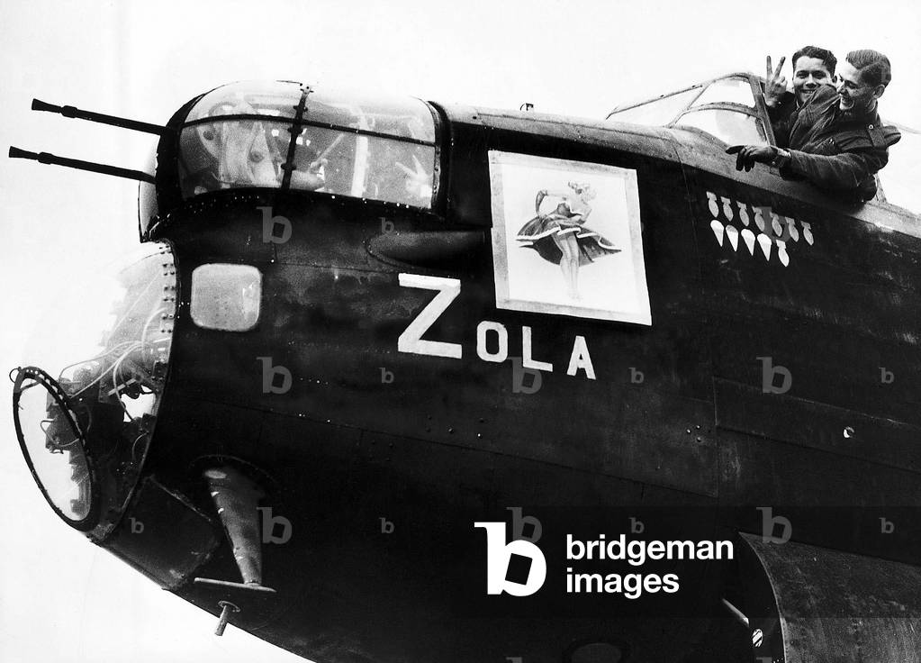 Crew of an RAF Avro Lancaster bomber point to nose art on their plane WW2, 1942 (b/w photo)