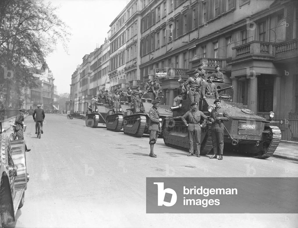Soldiers wait by their Vickers Medium tanks, parked in Pont Street London, on the 10th day of the General Strike. The national dispute came about after negotiations between the miners and mine owners failed over wages and the strike began on 3 May 1926. Millions obeyed the strike call, bringing transport systems to a halt while newspapers were not printed. The government responding by using volunteers to run trains and buses and sent in troops to move supplies from the London docks. There were clashes between police and crowds in many areas and at least 4000 strikers were arrested. There were attacks on buses and trains, including the derailing of the Flying Scotsman. The strike was called off unilaterally by the TUC on 12 May with no guarantees of fair treatment for the miners who fought on to bitter defeat in October, 4th May 1926 (b/w photo)