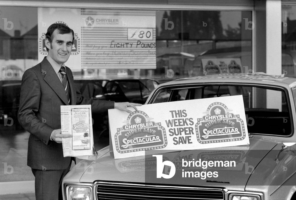 A car dealer putting cars on sale in his garage forecourt, May 1975 (b/w photo)