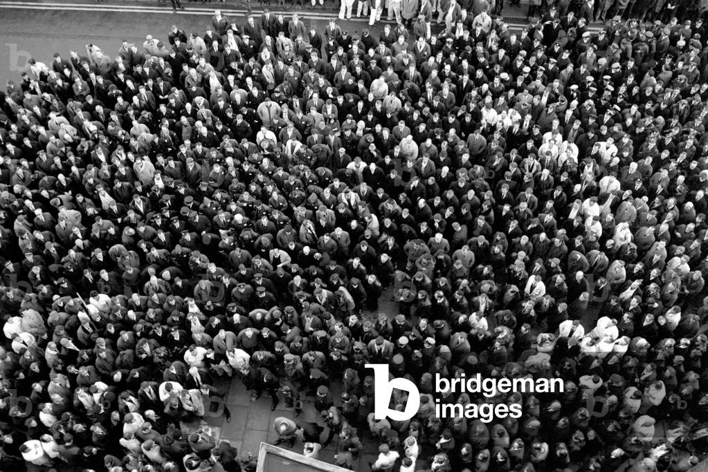 A thousand of Heathrow Airport's 30,000 ground staff stopped work for a mass demonstration today. 
 A view of the protest mass, taken from the 4th floor window of the tower, with them all looking up. 
November 1969