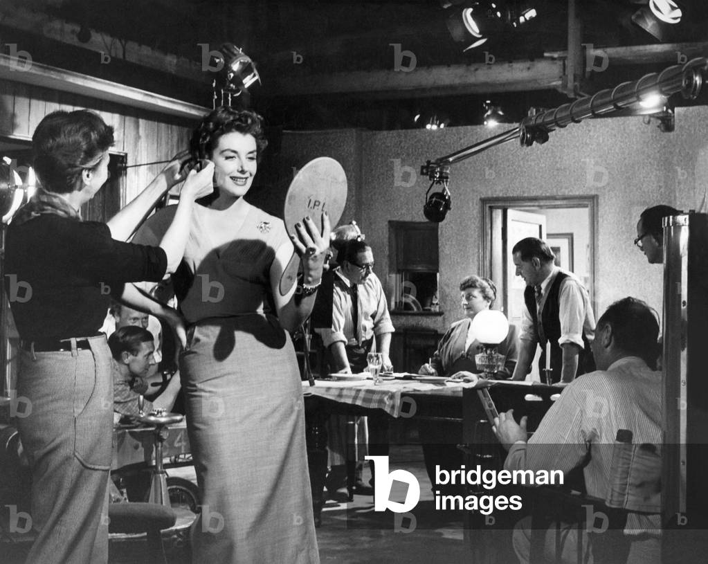 An un-named actress has her make-up touched up between filming at Ealing Studios, August 1953 (b/w photo)