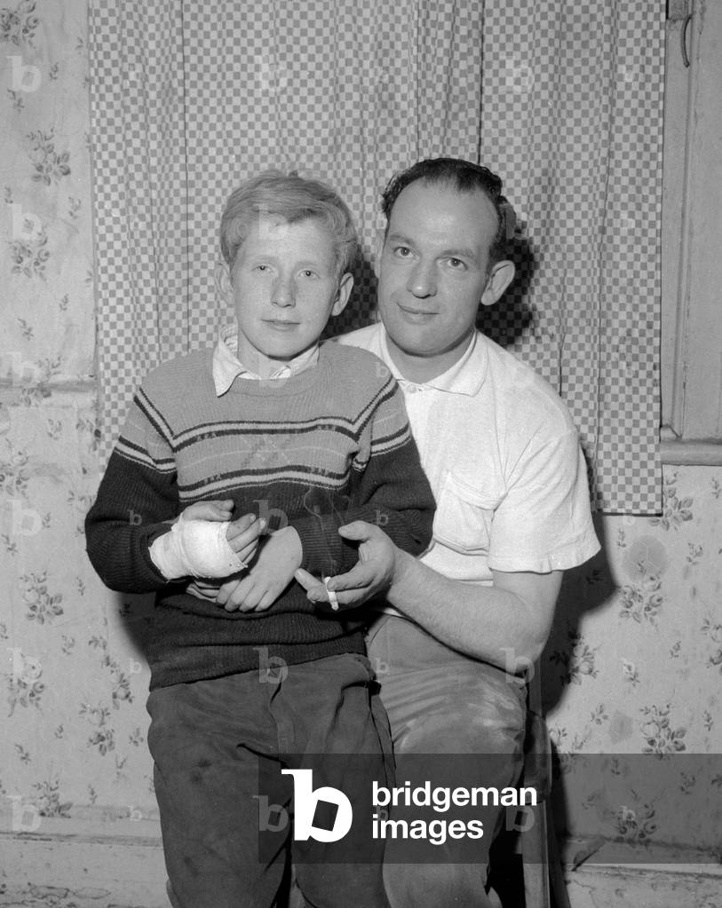 Young William McLoughlin with his mother Catherine pictured at home after leaving hospital following an accident in which a house roof collapsed in Stepney, London14th July 1961 (b/w photo)