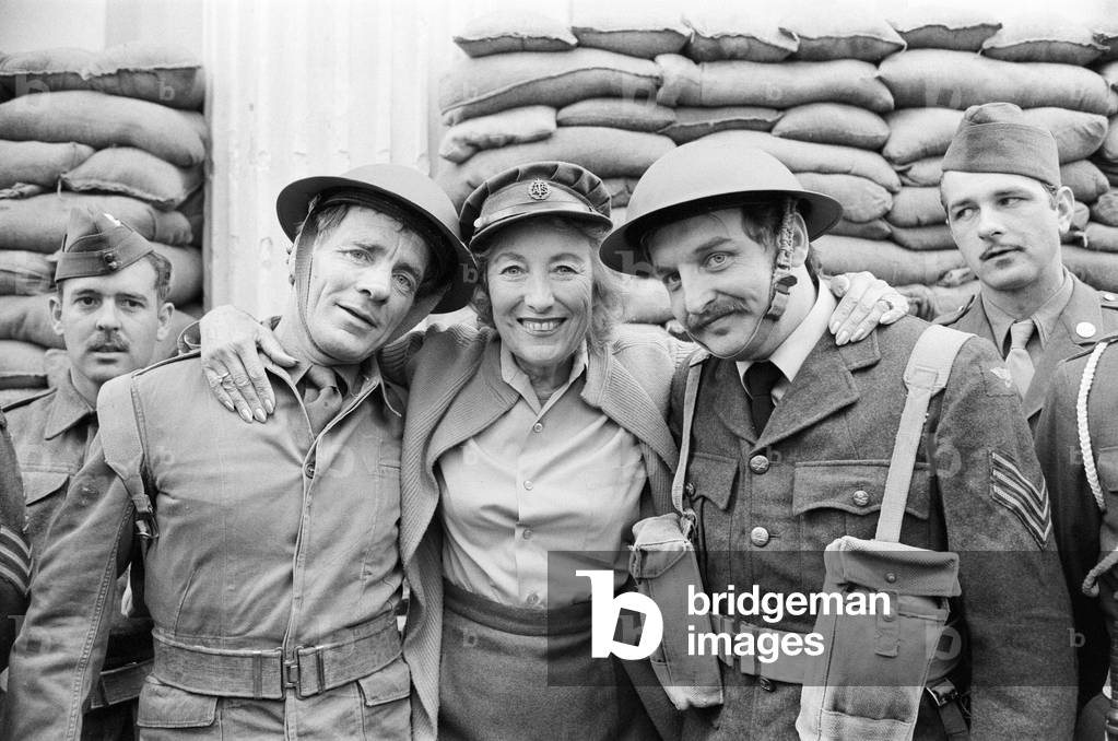 Dame Vera Lynn will appear at the Lyceum in 'Stage Door Canteen' to celebrate the 40th Anniversary of D Day. The front is sandbagged and Vera was wearing World War Two uniform for the photocall, she is pictured with some of the troops outside the theatre. 3rd June 1984 (b/w photo)