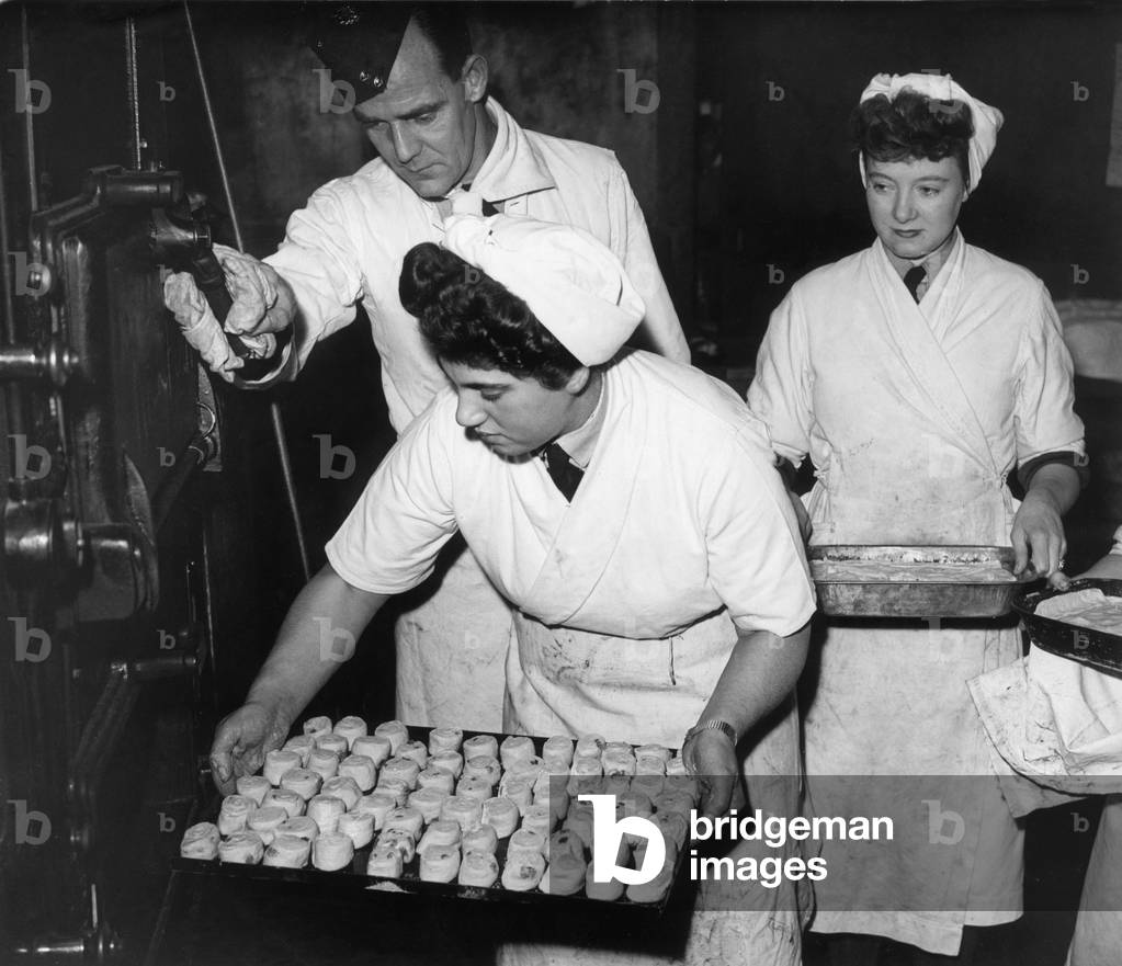 Women baking Swiss Rolls and sultana puddings, put their desserts into the oven during the Diploma course at the John Heddon RAF Cookery School in Hatton, 7th November 1944