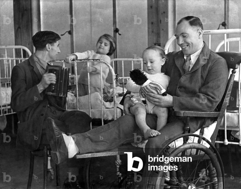 World War II: Wounded. A/C Blythe, R.A.F and Guardsman Shancks, are patients in the Royal National Orthapaedic Hospital at Stanmore, and are happy when allowed to visit the childrens' ward. They got to know all the little patients in the ward who call them their uncles. December 1943