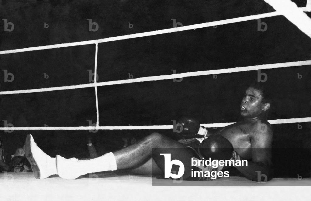 Muhammad Ali (born Cassius Marcellus Clay, Jr.; January 17, 1942) is an American former professional boxer, generally considered among the greatest heavyweights in the sport's history. A controversial and polarizing figure during his early career, Ali is widely regarded for the skills he displayed in the ring plus the values he exemplified outside of it. (Pictures shows) Cassius Clay on the canvas after taking a left hook from British challenger Henry Cooper. 18th June 1963 (b/w photo)