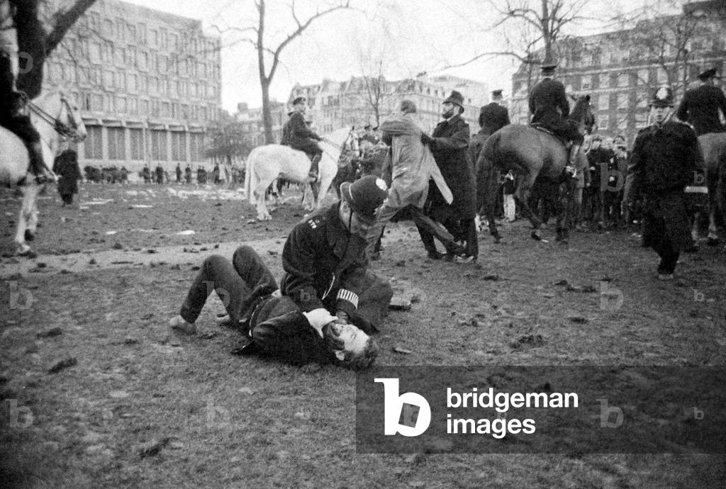 A policeman pins down a demonstrator during Riots at US Embassy, Grosvenor Square, over the on-going Vietnam Conflict, March 1968 (b/w photo)
