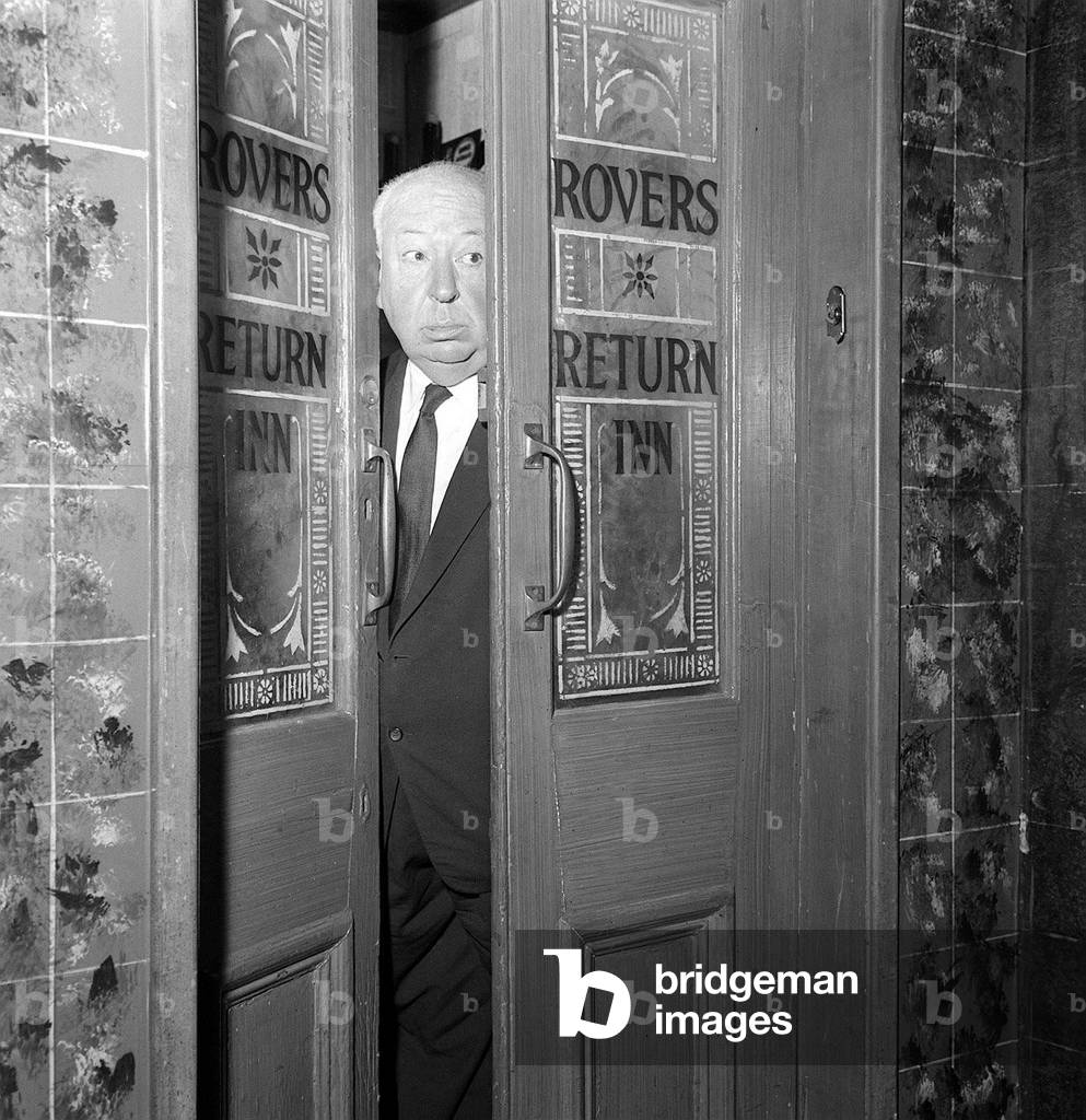 Alfred Hitchcock, film director In studio 2 with props from the Rovers Return Coronation Street at Granada Studios, June 1964 (b/w photo)
