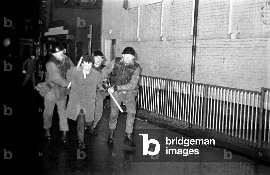 Northern Ireland Londonderry February 1970. Londonderry riots, Army riot squad arresting rioters as injured soldiers are being led away. February 1970 70-1608