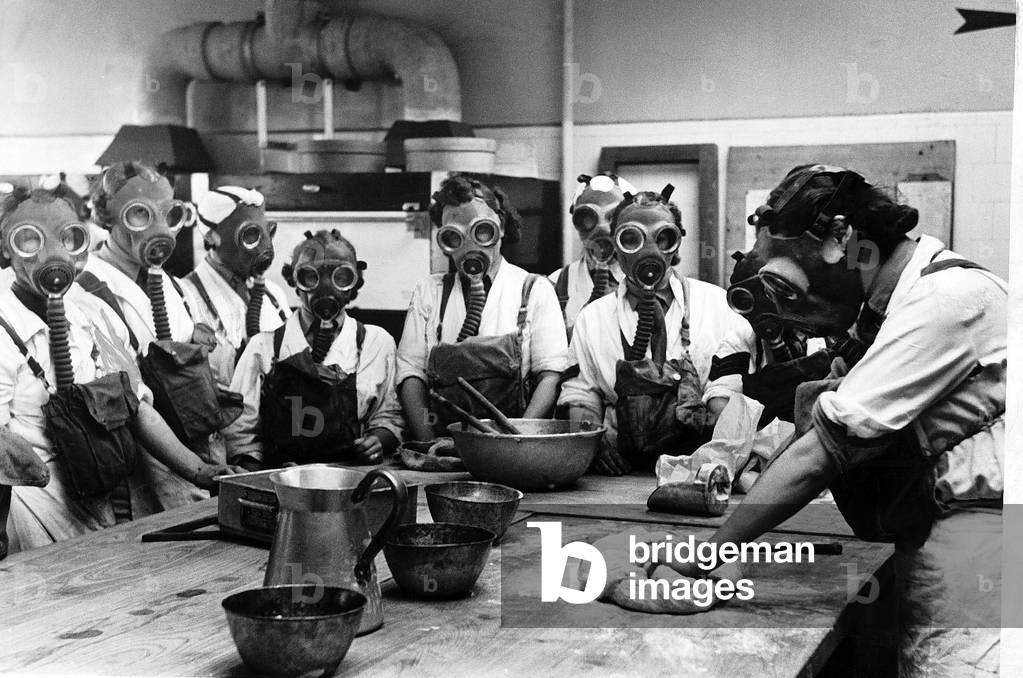 WW2 Army cookery school, June 1941. 
Women wearing gas masks while watching a cookery demonstration