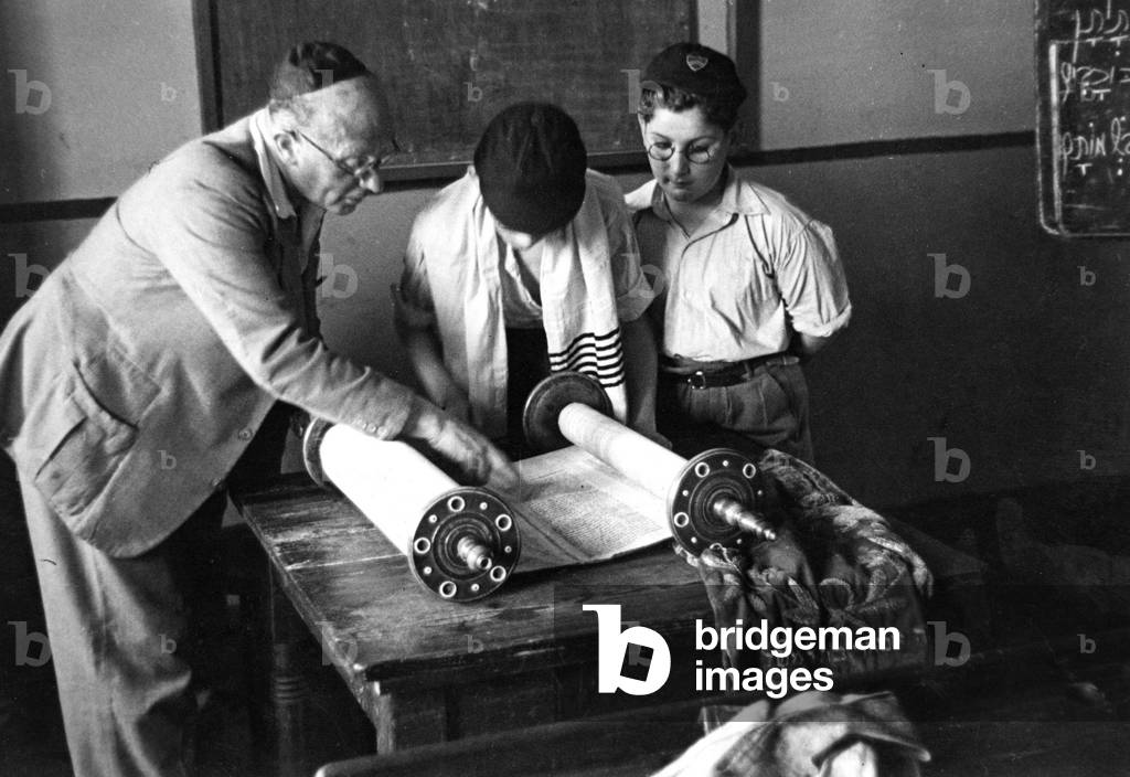 Preparing for their Bar-mitzvah, two boys attend the Whitechapel Talmud Torah School, where they study from the Torah, or scroll of law.
Circa 1947