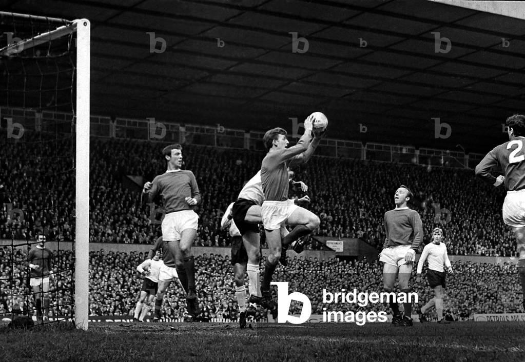 Manchester United goalkeeper Alex Stepney jumps up to claim a high ball in the United penalty area watched by defender David Sadler during their league match against Sheffield United at Old TraffordApril 1968 (photo)