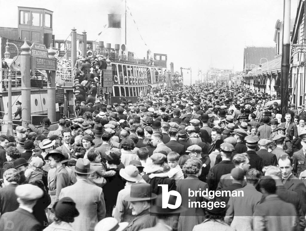 Holiday makers on the landing stage and ferry boats headed for New Brighton. Pier head, Liverpool, Merseyside. 18th May 1937 (b/w photo)